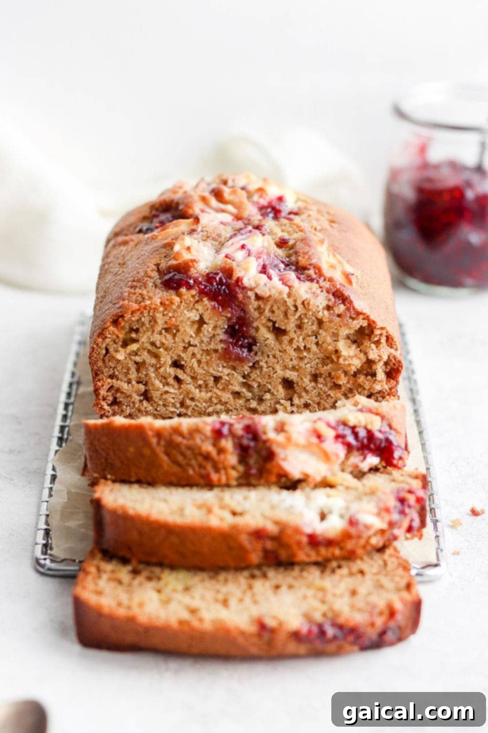 Beautifully sliced lemon bread with raspberry cream cheese swirl on a wooden board