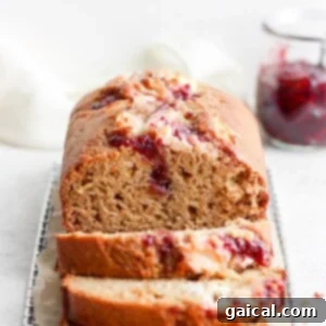 A whole loaf of lemon bread with a prominent raspberry cream cheese swirl