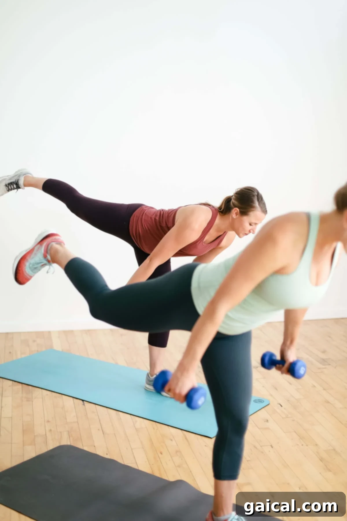 Build a Better Booty 3 Two women performing a bodyweight squat during a workout session