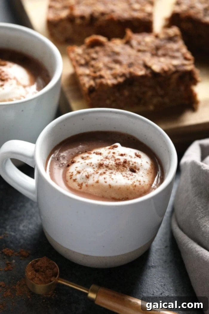 Comforting Vegan Chai Hot Chocolate 2 A steaming mug of creamy vegan chai hot chocolate with a cinnamon stick garnish