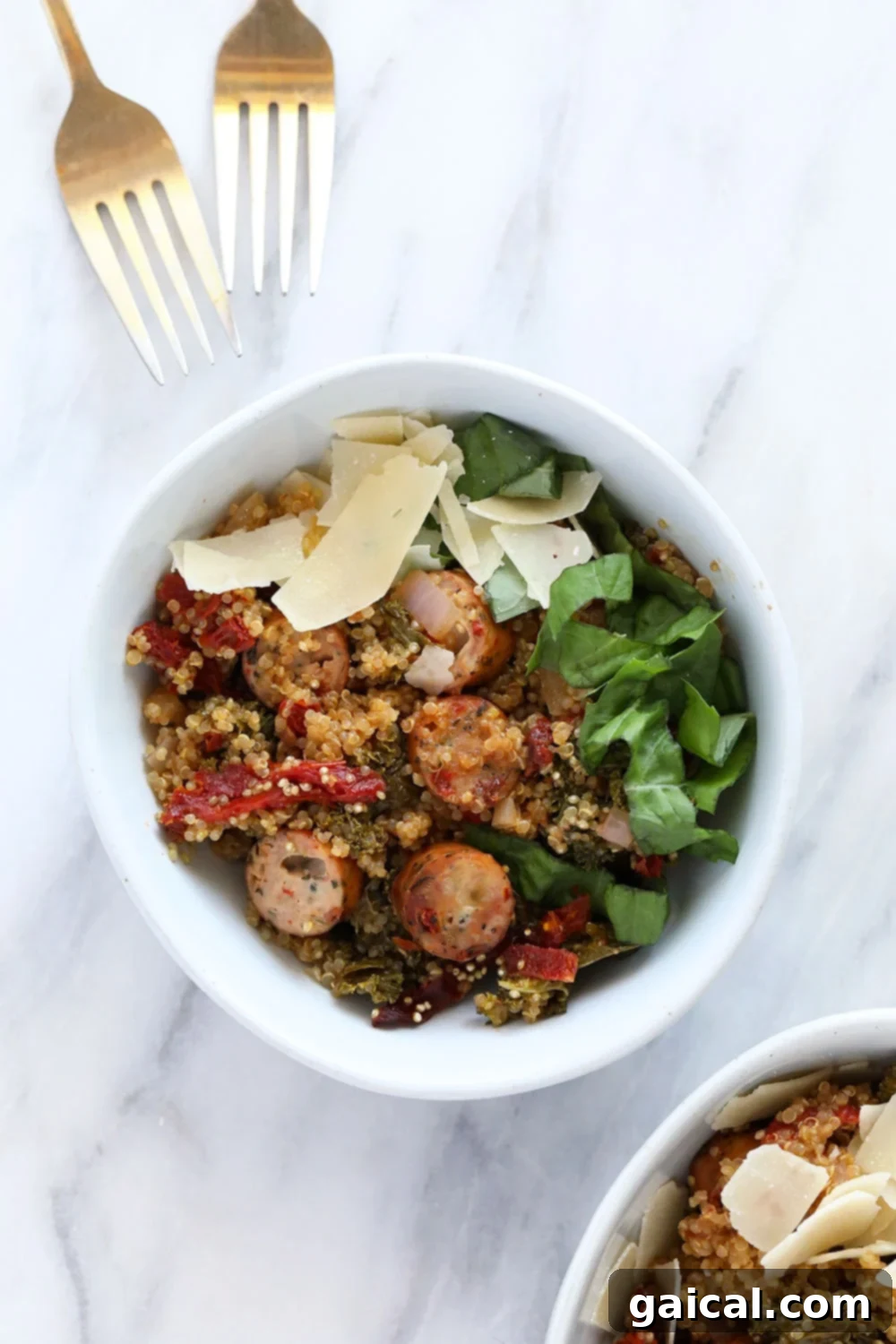 A vibrant Italian chicken sausage quinoa casserole in a serving bowl, ready to eat, topped with fresh basil and parmesan.