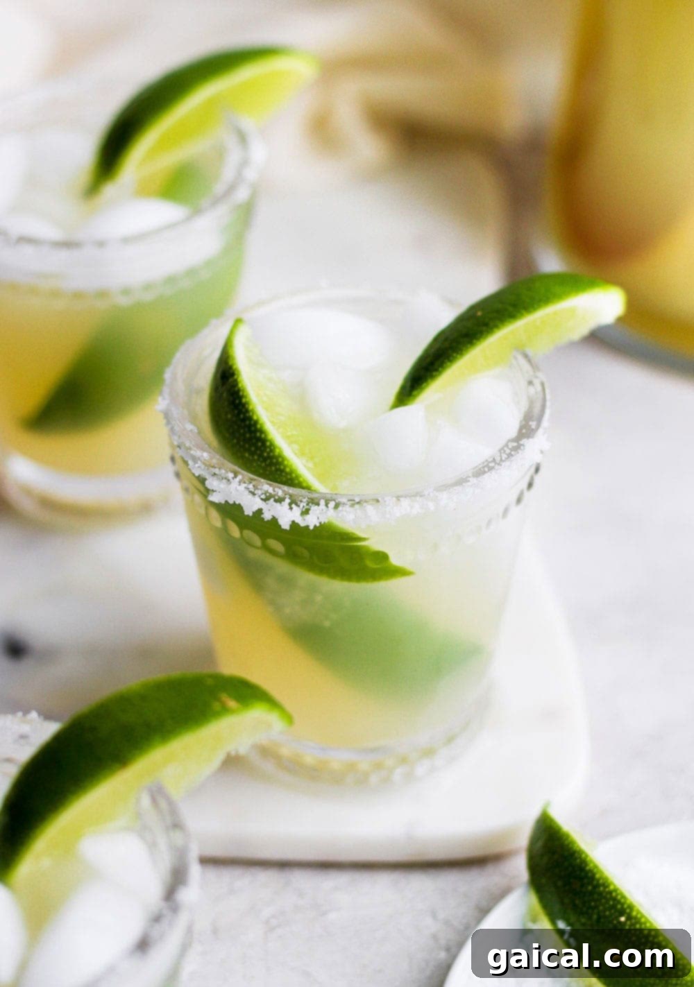 Delicious skinny margaritas made with just 4 simple ingredients- lime juice, tequila, ice, and your favorite all-natural sweetener! A refreshing skinny margarita in a glass, garnished with a lime slice.
