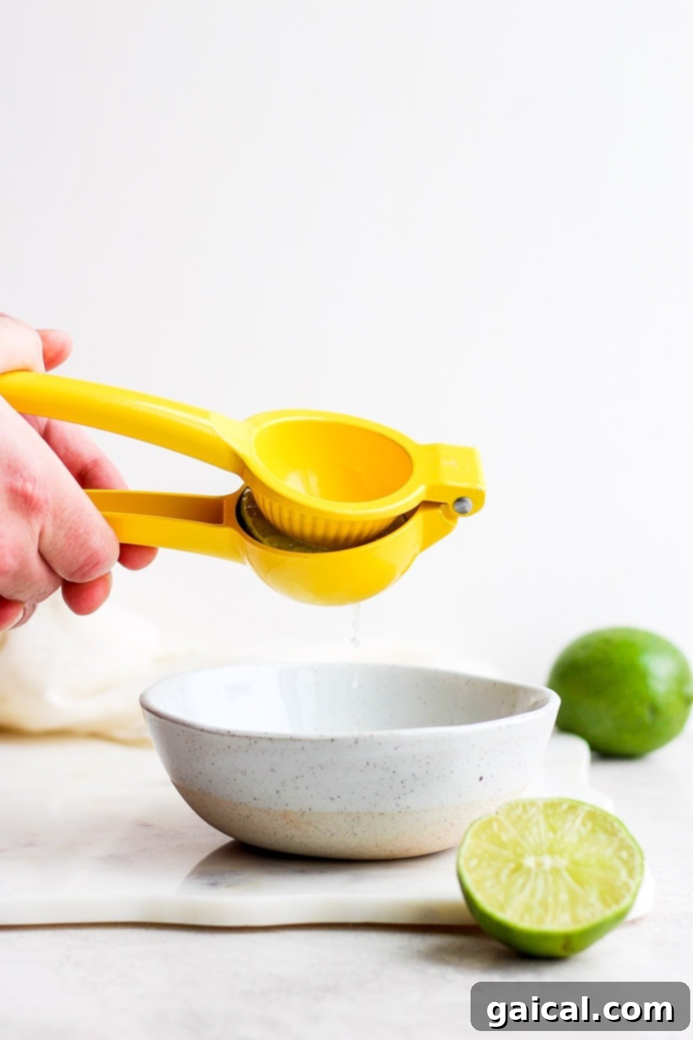 This is the BEST skinny margarita on the internet and it's made with 4 simple ingredients - tequila, fresh lime juice, ice, and honey/agave simple syrup! Close-up of hands juicing fresh limes, essential for a flavorful skinny margarita.
