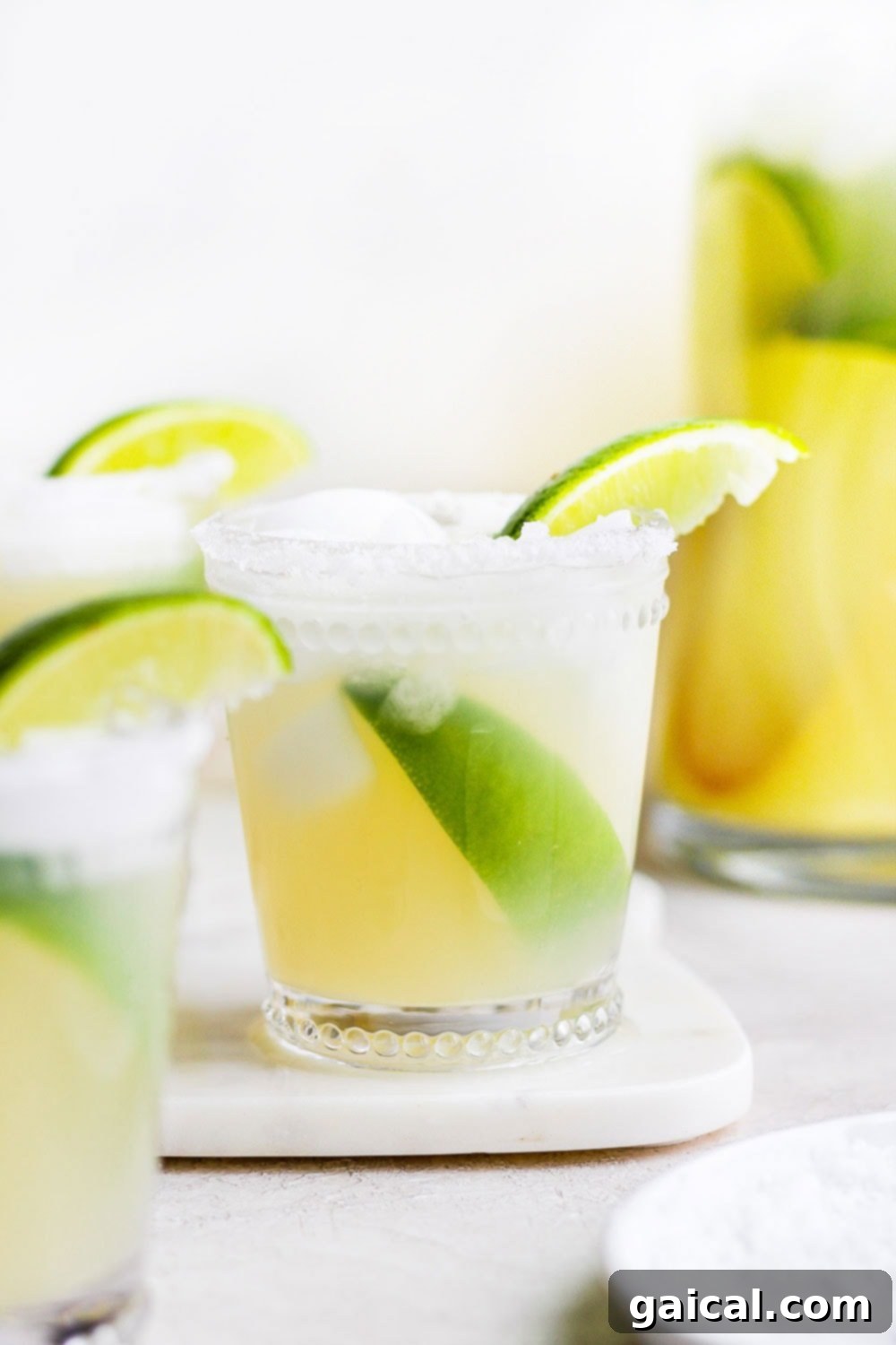 This is the BEST skinny margarita on the internet and it's made with 4 simple ingredients - tequila, fresh lime juice, ice, and honey/agave simple syrup! A skinny margarita in a glass, garnished with lime wedges and a salted rim.