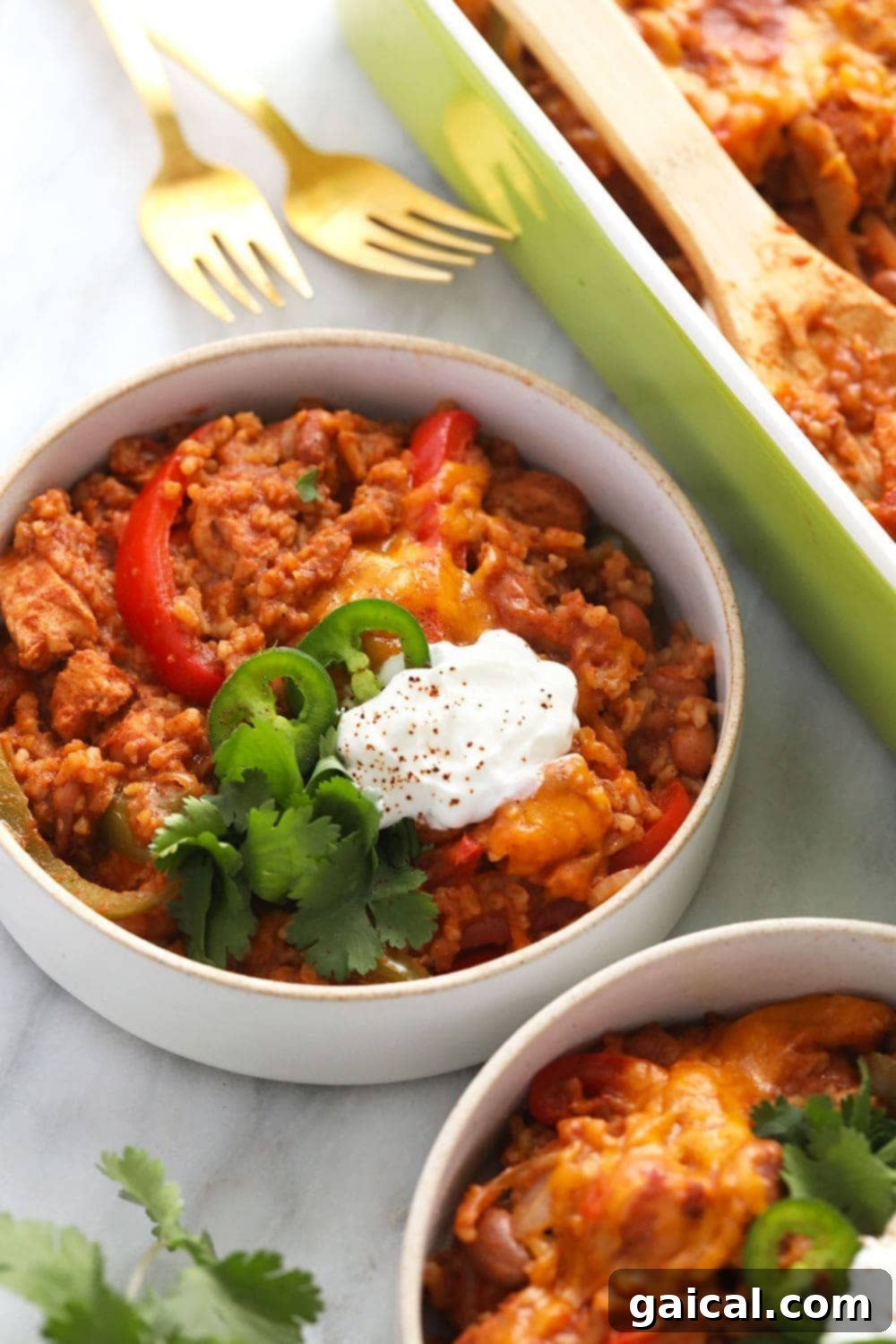 Healthy Chicken Burrito Bowl Casserole served in a bowl, topped with sliced jalapeños and a dollop of Greek yogurt