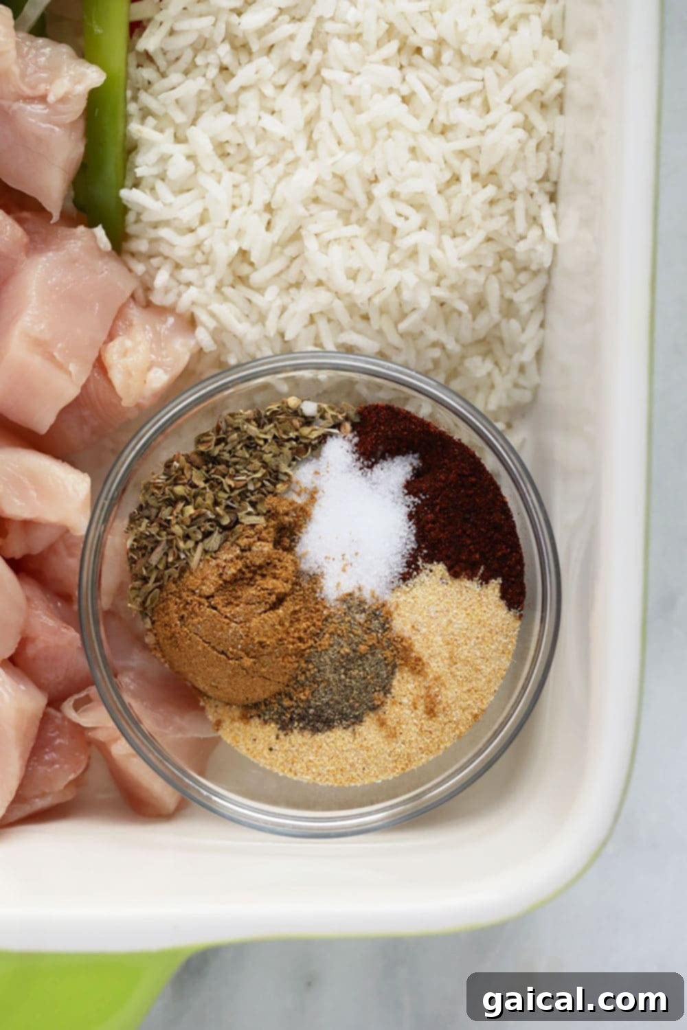 A collection of Mexican spices including chili powder, cumin, garlic powder, and oregano, ready for use