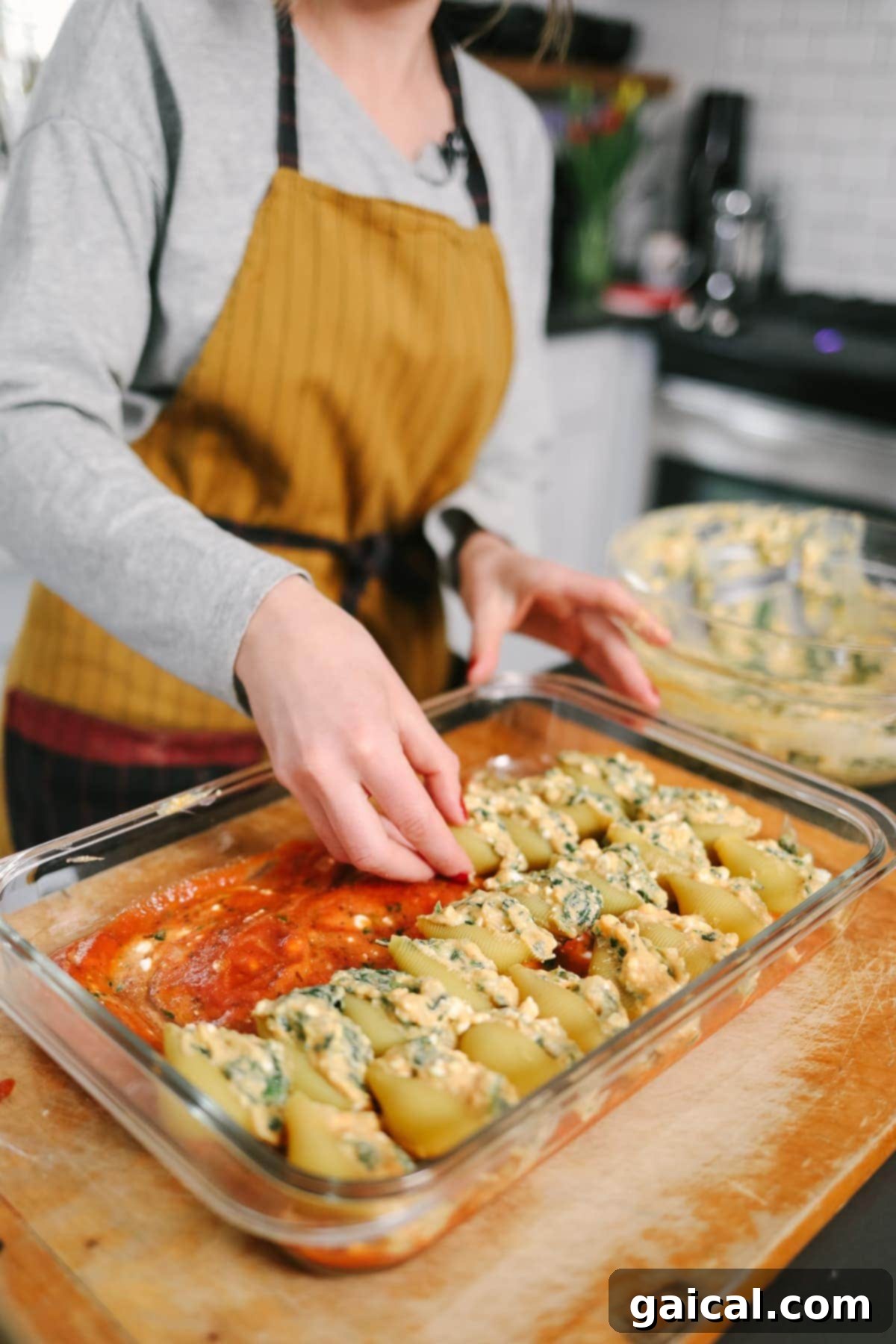 Beautifully arranged sweet potato and spinach stuffed shells in a casserole dish.