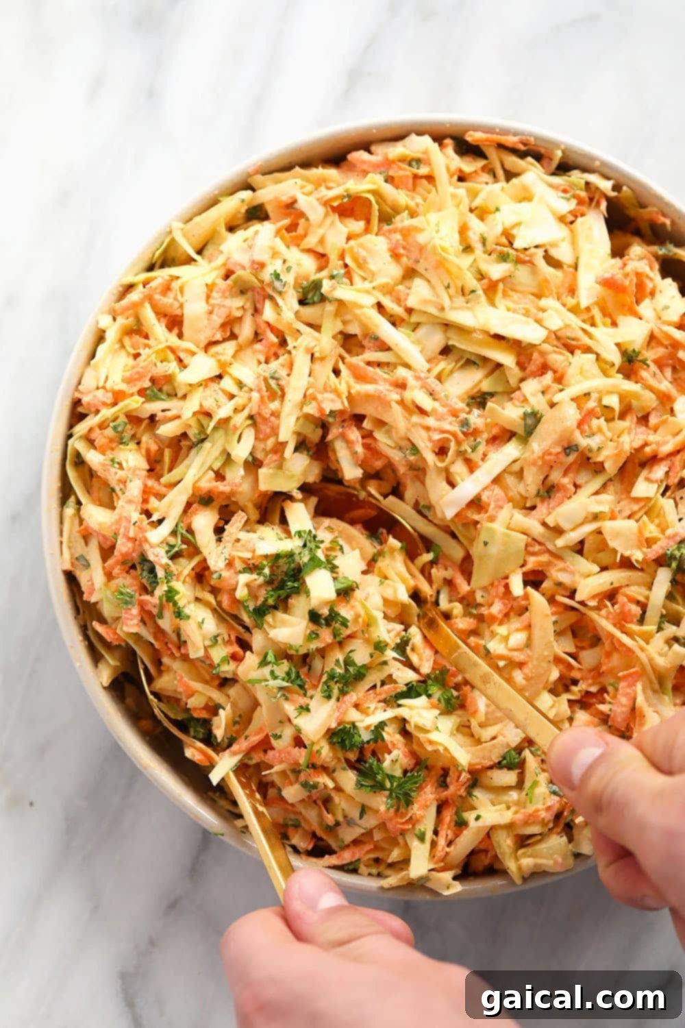 This Creamy Coleslaw Recipe is the perfect summer side dish for your next backyard BBQ! creamy coleslaw in a bowl being served with serving spoons