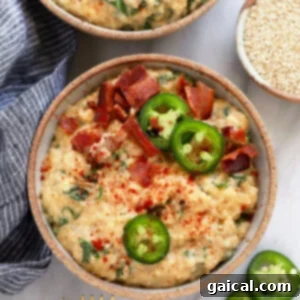 A bowl of creamy quinoa mac and cheese, ready to be enjoyed, topped with jalapeños and bacon.