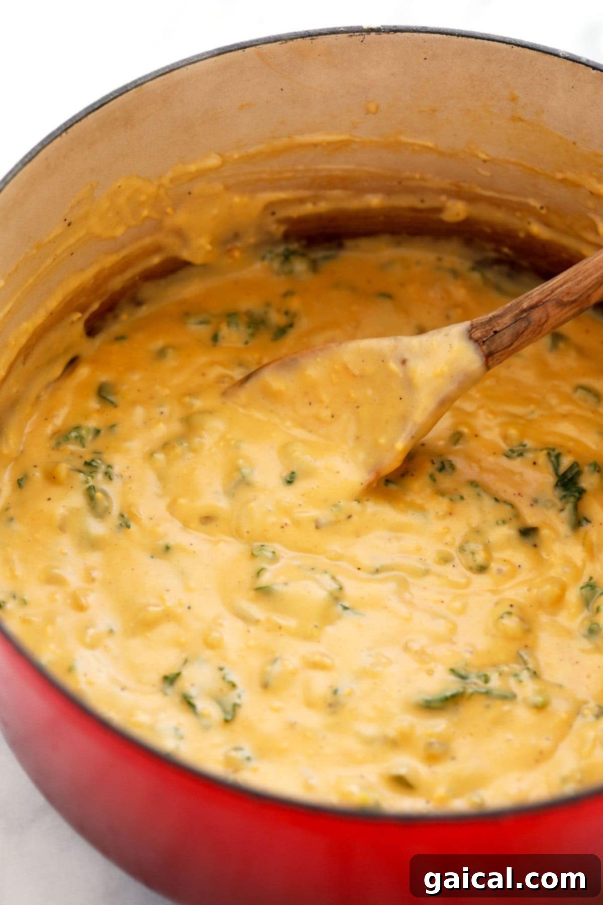 Wholesome Quinoa Mac 6 The rich, creamy cheese sauce perfectly coating fresh, vibrant kale, ready to be combined with quinoa for a wholesome mac and cheese.