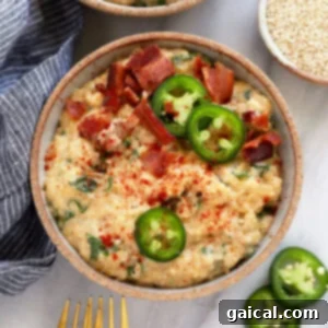 Creamy Quinoa Mac and Cheese, ready to be served from a bowl, garnished with jalapeños and bacon.