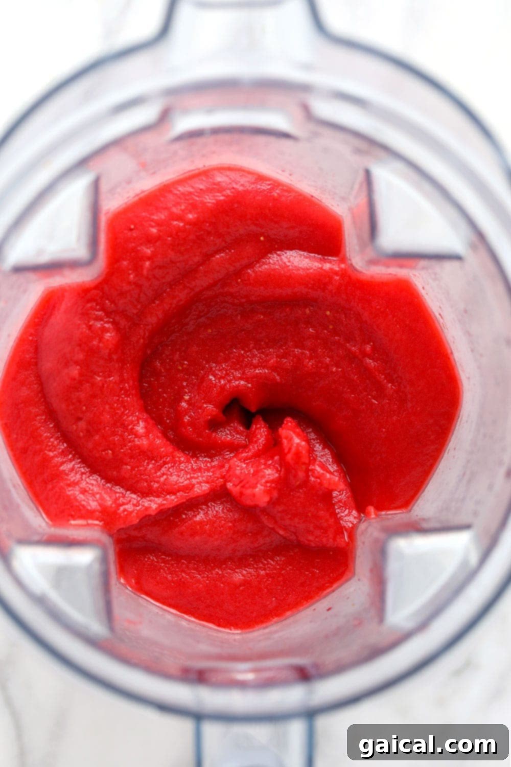 Three perfectly blended strawberry daiquiris in elegant glasses, garnished and ready to serve, showcasing their vibrant color and smooth texture.