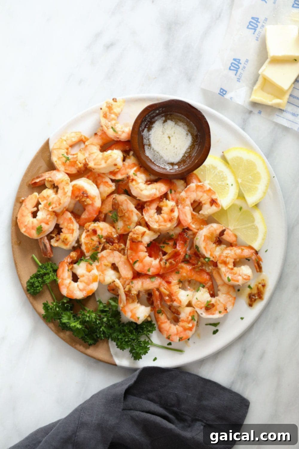 A vibrant plate of garlic butter shrimp, perfectly cooked and garnished with fresh lemon slices, ready to be enjoyed.