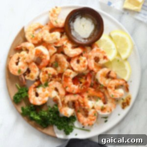 A stunning plate of garlic butter shrimp, perfectly cooked and glistening, with fresh lemon and herbs.