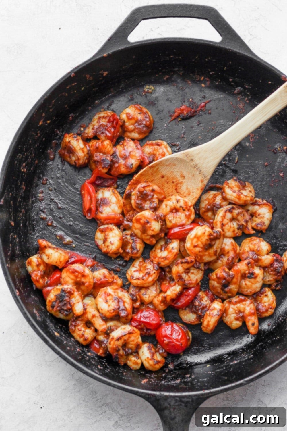 Shrimp being cooked to perfection in a cast iron skillet, showing a beautiful pink color.