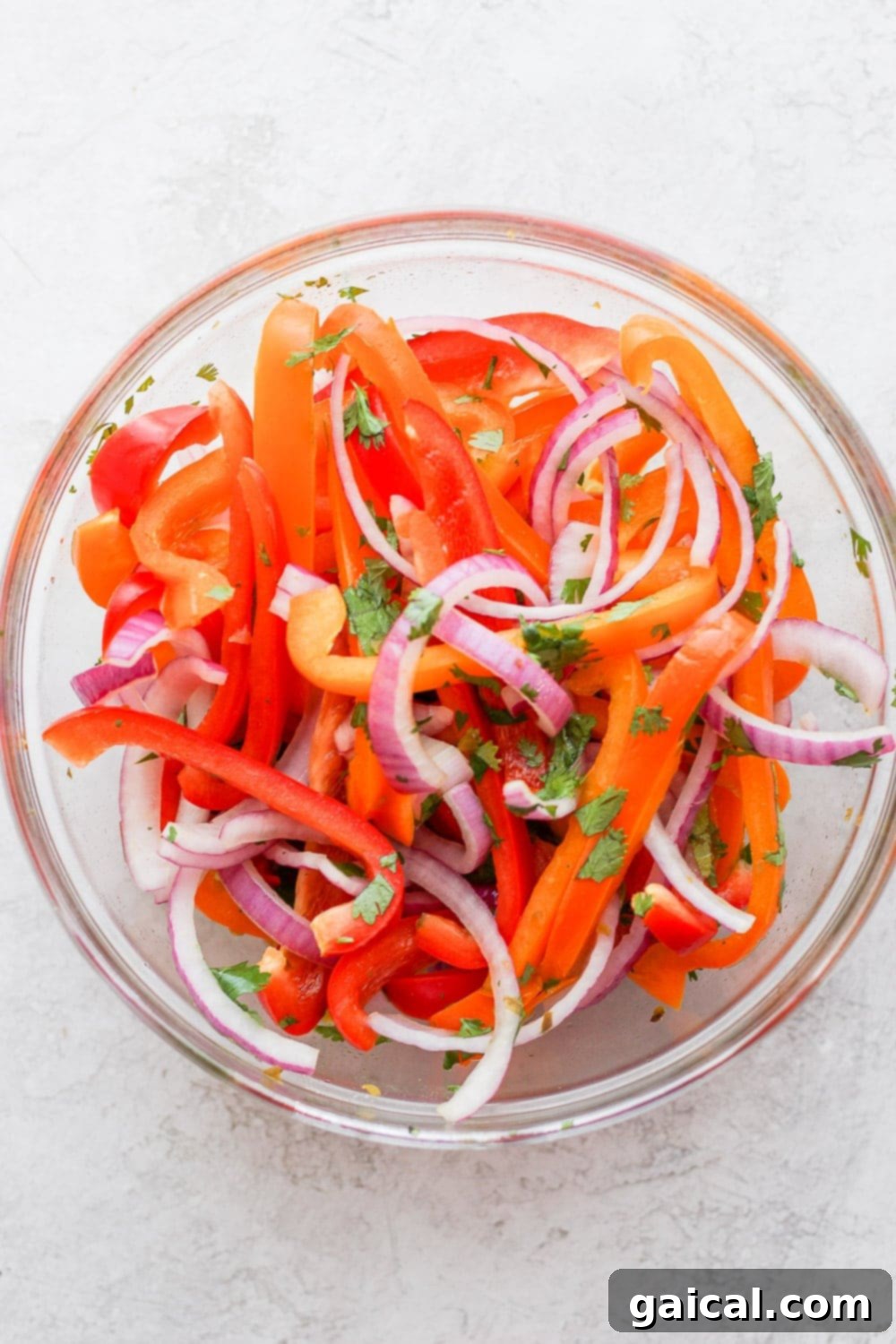 Vibrant sweet pepper slaw being mixed together in a large bowl, showcasing fresh ingredients.