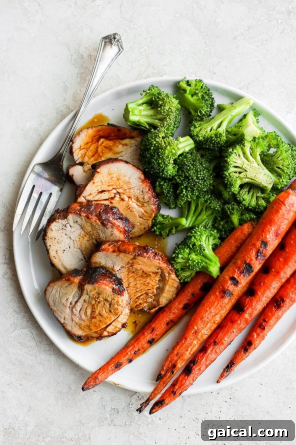 The Best Grilled Pork Tenderloin: Dry-Rubbed and BBQ Marinated Perfectly sliced grilled pork tenderloin with roasted vegetables, ready to serve.