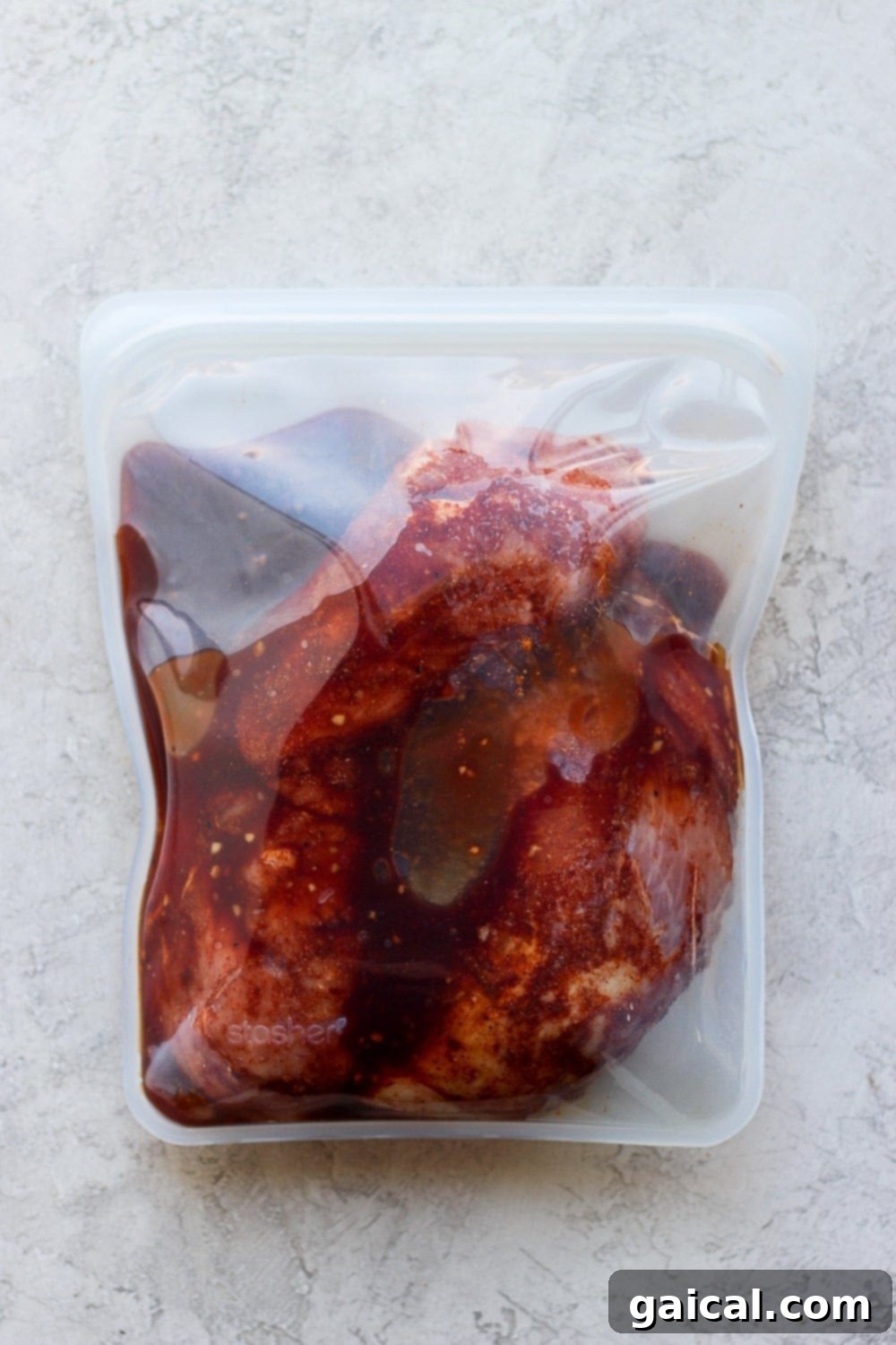 Easy Grilled Pork Tenderloin Marinade Pork tenderloin marinating in a Stasher bag with BBQ and soy sauce mixture.