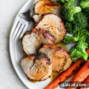 Grilled pork tenderloin served with vibrant grilled carrots and asparagus.