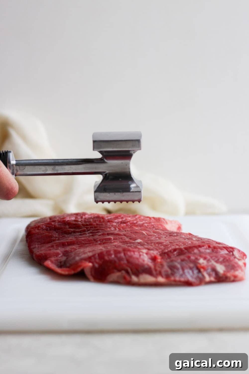 Grilled flank steak is so flavorful and tender! It is the perfect cut of meat for fajitas, tacos, or all by itslef! Pounding flank steak down to ensure an even thickness for uniform cooking.