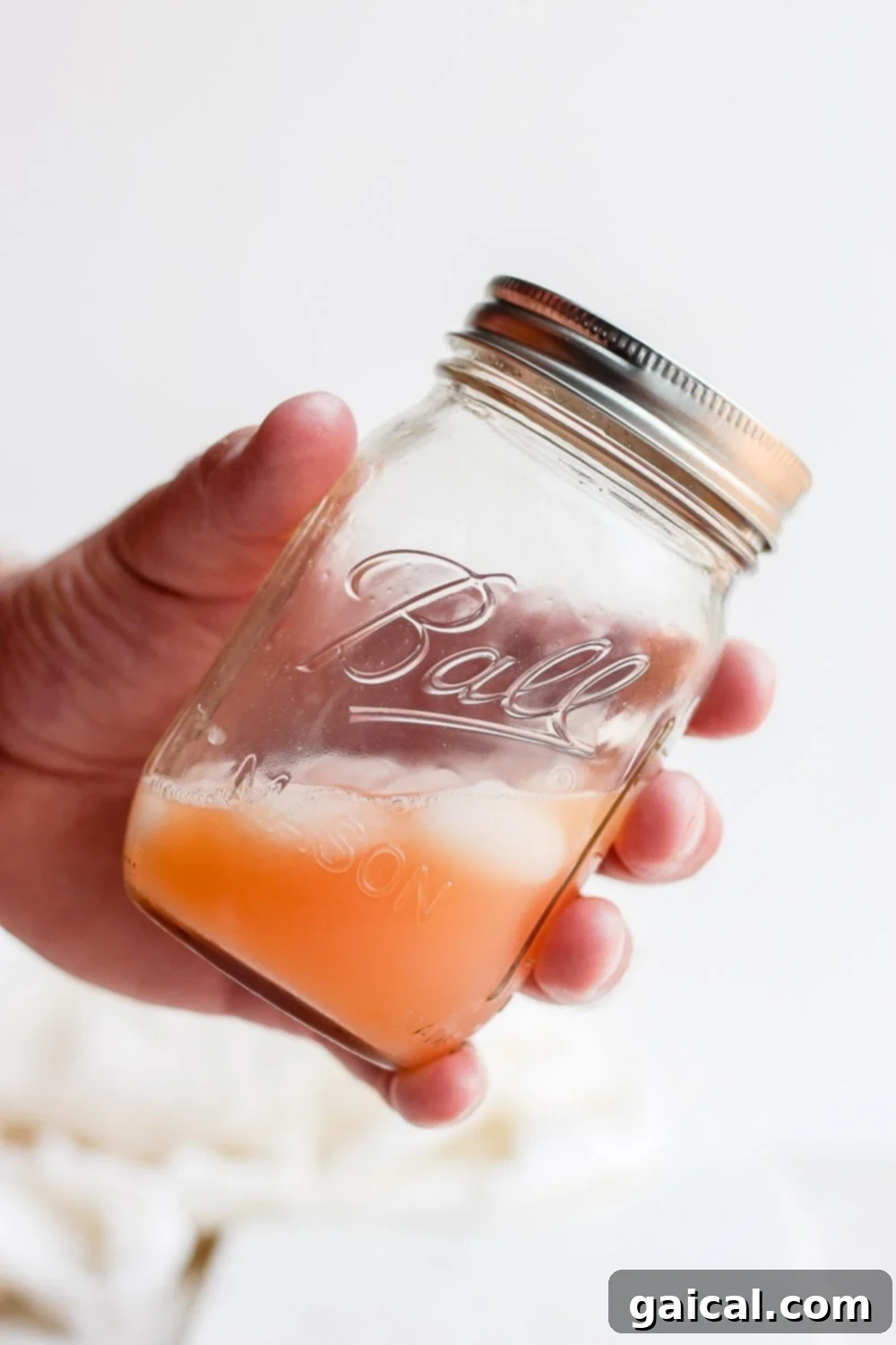 Paloma in a Mason Jar A refreshing Paloma cocktail served over ice in a mason jar, highlighting its cool and inviting appearance.