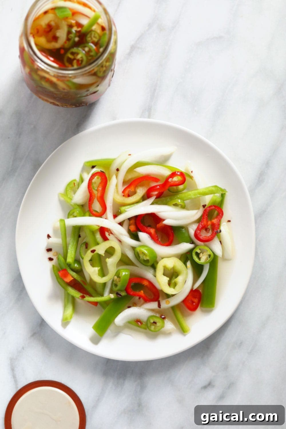 All the ingredients for quick pickled peppers laid out on a white plate