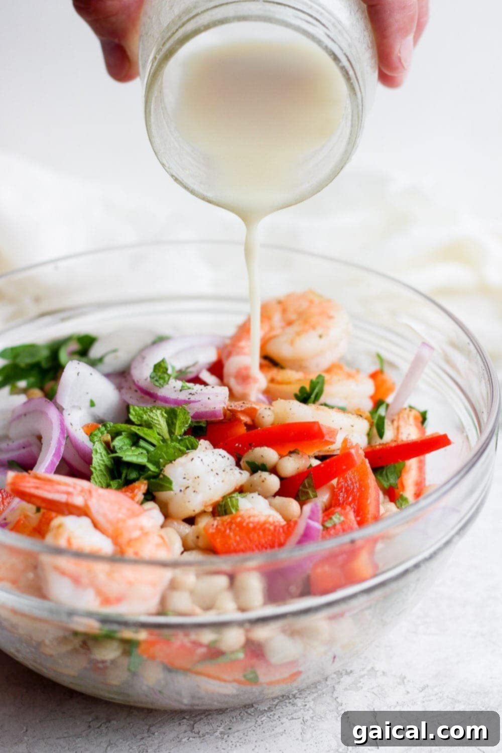 Vibrant Shrimp Salad 7 creamy dressing being poured over healthy shrimp salad