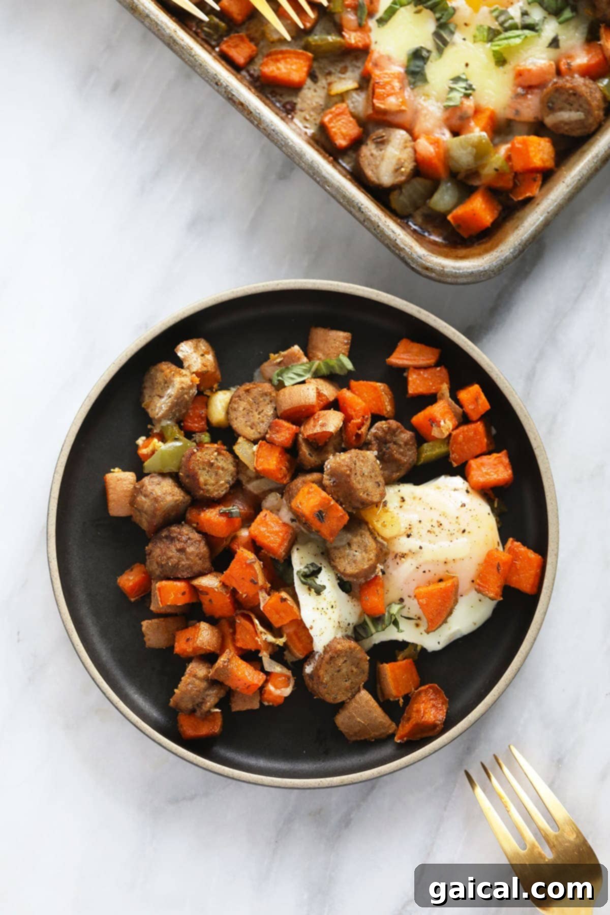 A single serving of sweet potato hash with a perfectly baked egg on a white plate, garnished with fresh herbs.