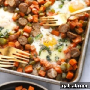A vibrant sheet pan sweet potato hash topped with perfectly baked eggs and fresh herbs, ready to be enjoyed.