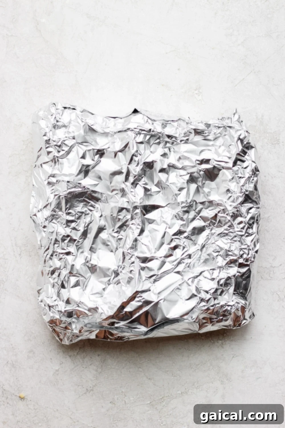 Foil Packet Grilled Corn 6 A perfectly sealed foil packet containing an ear of corn, showcasing the ideal wrapping for grilling.