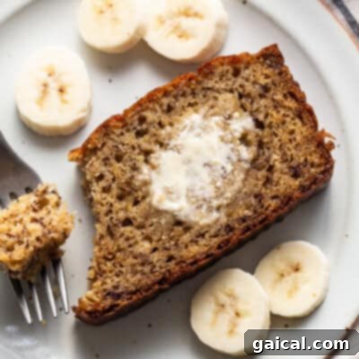 A slice of banana bread on a plate with a fork.