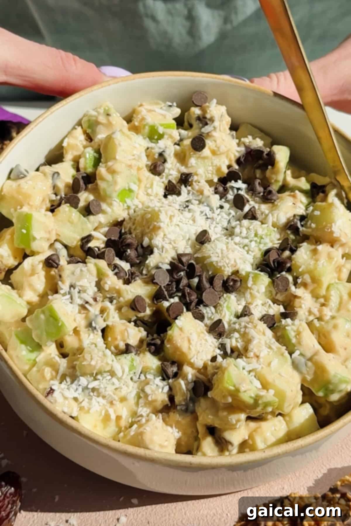 A delectable bowl of Caramel deLites Apple Salad, topped with shredded coconut and chocolate chips.