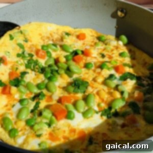 Adding vegetables to the omelette
