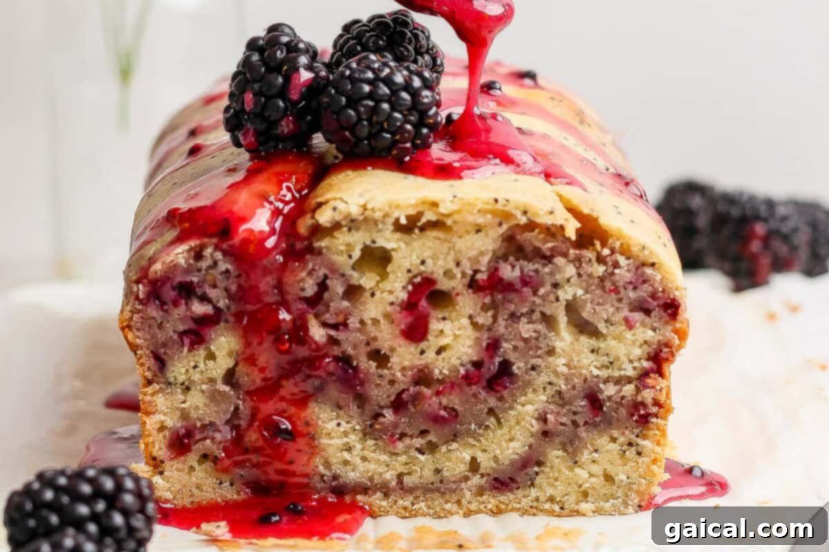 A luscious blackberry lemon poppy seed loaf, adorned with fresh blackberries and a drizzle of blackberry glaze.