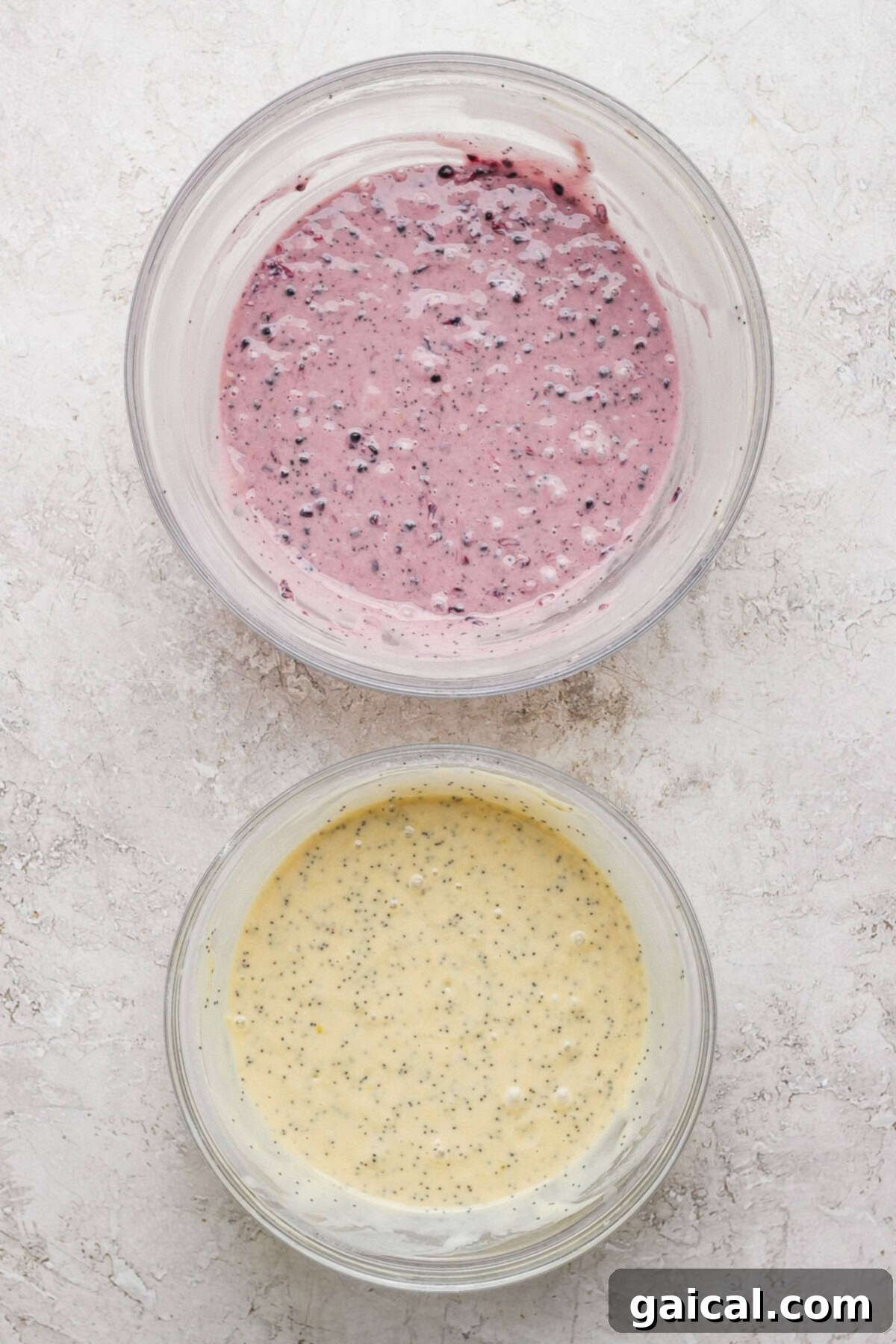 Two bowls of batter: one blackberry-infused purple batter and one lemon poppy seed batter.