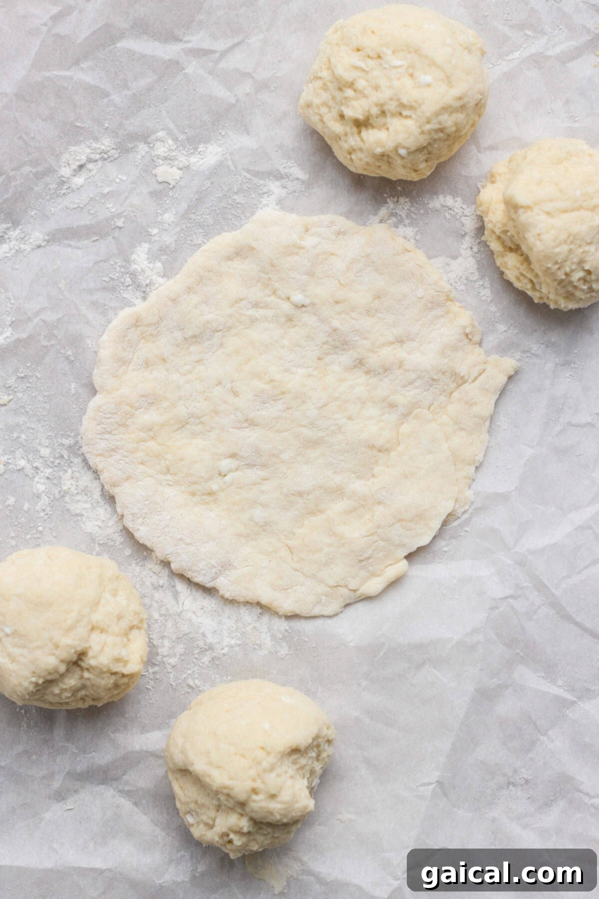 English muffin dough balls on parchment paper