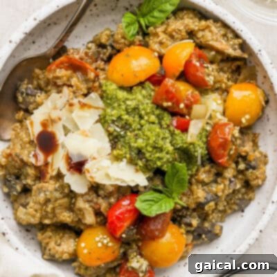 A rustic bowl of creamy risotto, adorned with vibrant tomatoes and fresh pesto, ready to be enjoyed.