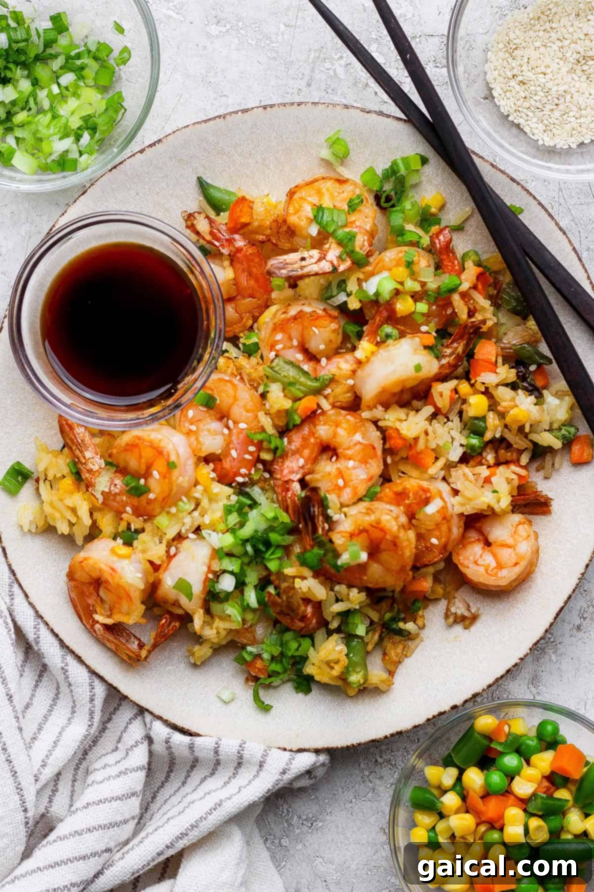 A beautifully plated dish of air fryer shrimp fried rice, served with chopsticks and a side of soy sauce. The crispy texture of the rice is visible.