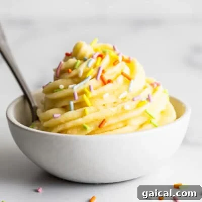 A bowl of ice cream with sprinkles and a spoon.