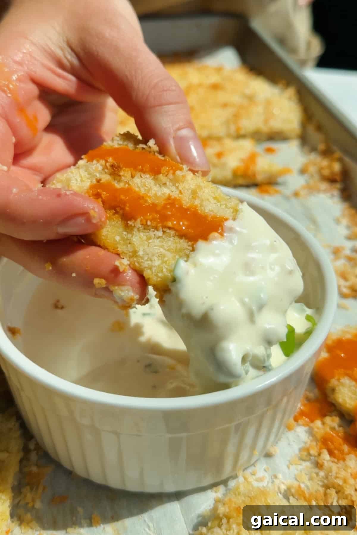 Buffalo Chicken Protein Bars — Crispy Baked Savory Snack 2 Dipping a buffalo-sauced chicken protein bar into creamy blue cheese dressing