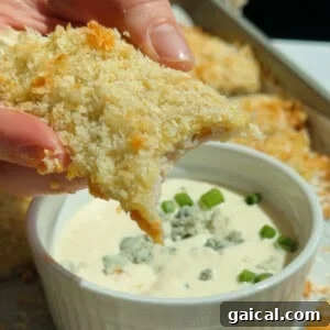 Buffalo Chicken Protein Bars — Crispy Baked Savory Snack 15 Dipping a crispy chicken protein bar into blue cheese dressing topped with crumbled cheese and green onions