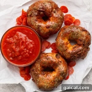 Pizza protein bagels with Italian seasoning served with marinara sauce and pepperoni slices