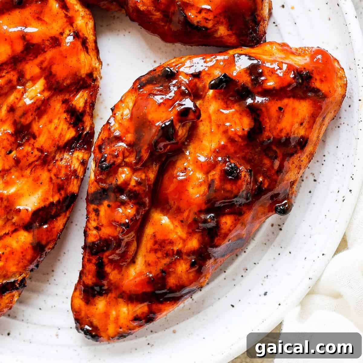 bbq chicken breasts on a white plate.