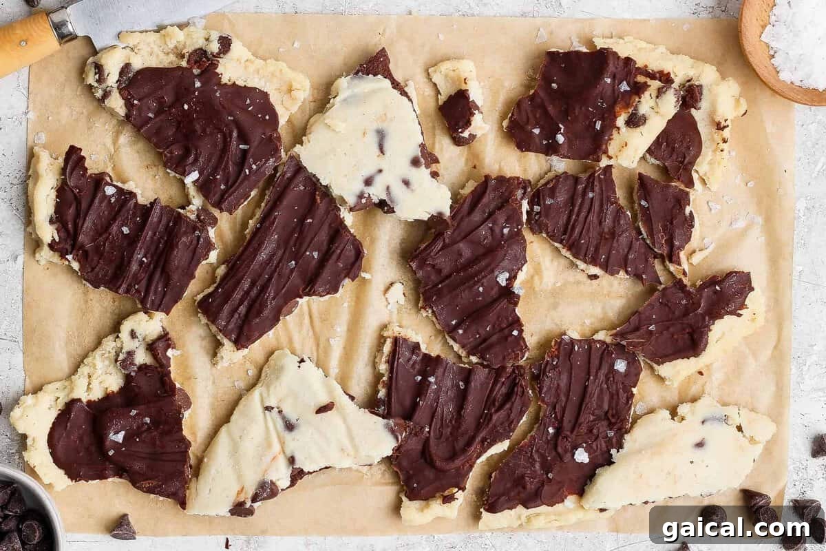 cottage cheese cookie dough bark broken into pieces on parchment paper