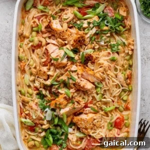 Salmon casserole with rice noodles, baked salmon chunks, cashews, green onions, cilantro, and chili crunch Boursin sauce in a white baking dish
