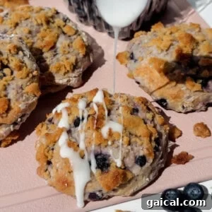 blueberry cottage cheese biscuits with streusel topping and white glaze on a pink tray