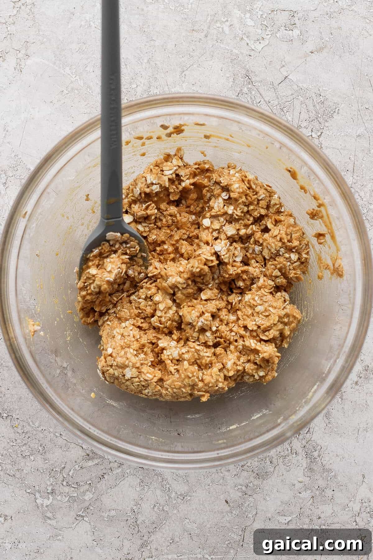 stirring peanut butter oat crumble topping with a spatula until clumpy