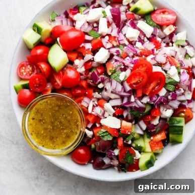 Greek salad recipe with tomatoes, cucumbers, and onions.