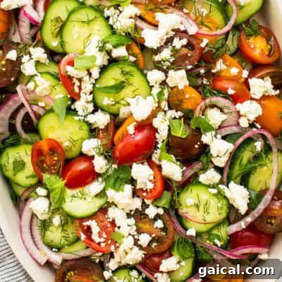 a refreshing cucumber tomato salad topped with feta cheese.