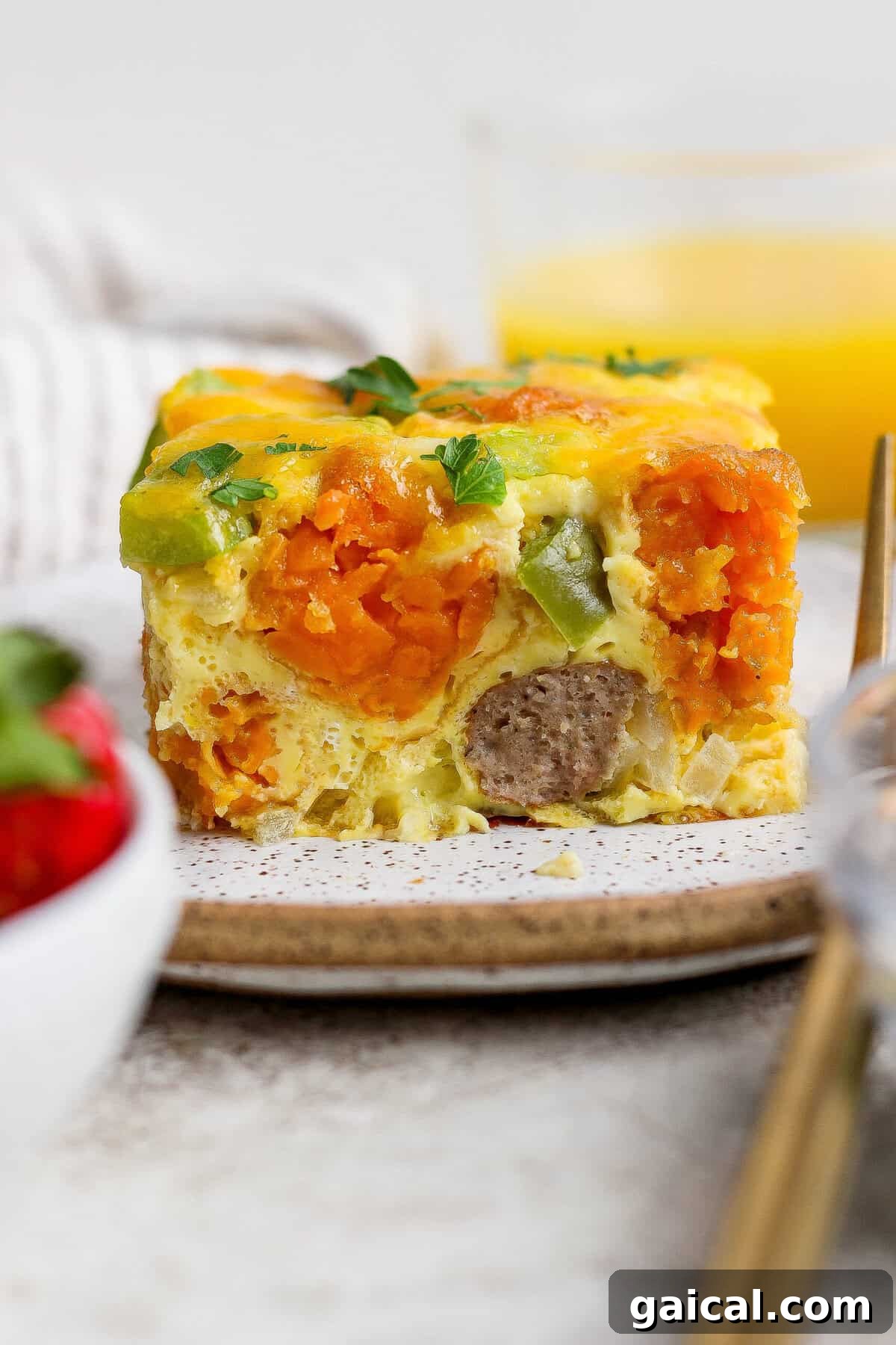 plated slice of sweet potato breakfast casserole showing layers of tater tots and sausage